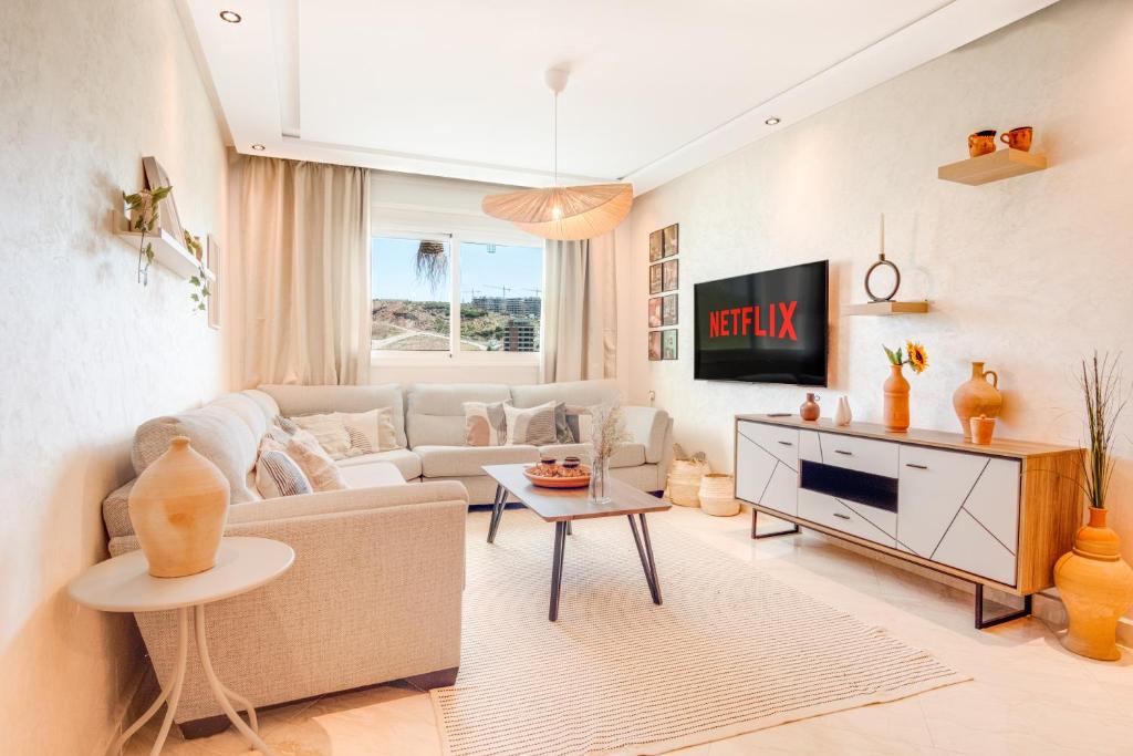 a living room with a couch and a table at Tanger Malabata - Chique & Stylish 2BR Apartment - Fast WiFi & Netflix in Tangier