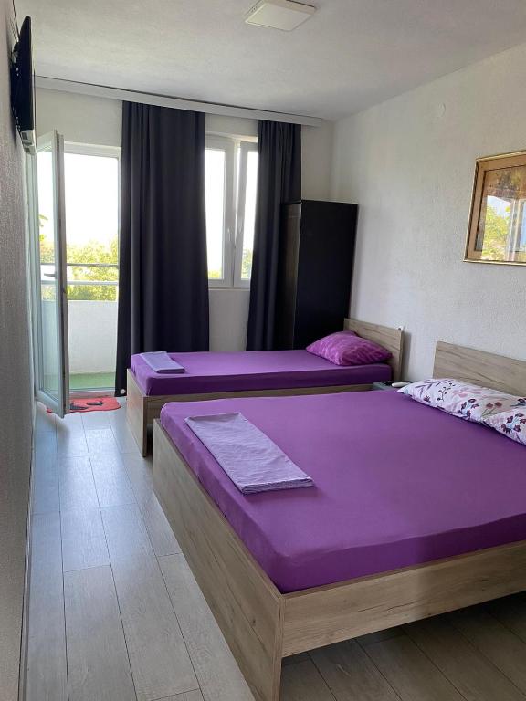 two beds in a room with purple sheets at Hris-An in Star Dojran