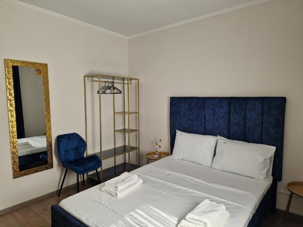 a bedroom with a bed and a chair and a mirror at Vila Andora in Eforie Nord