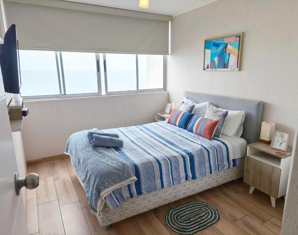 利马EuVe Ocean View Flat in Lima的小卧室配有一张带蓝色毯子的床