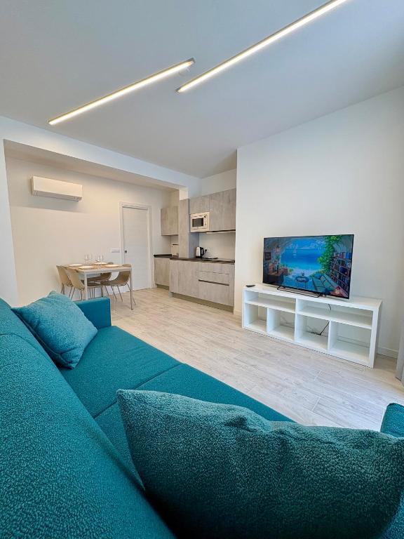 a living room with a blue couch and a tv at Residence Corallina in Caorle