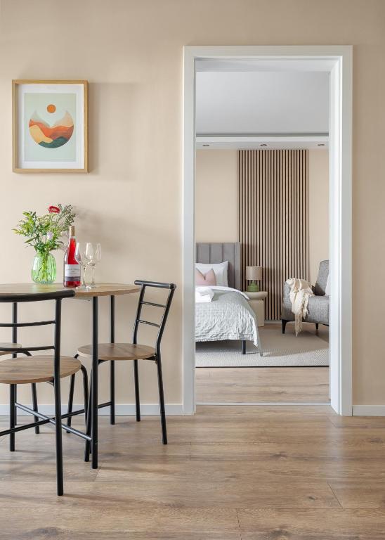 a dining room with a table and a bedroom at Dolce Apartmanház in Eger
