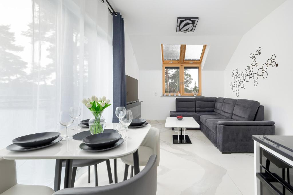 a living room with a table and a couch at Amber Baltic Apartment by Solarento in Niechorze