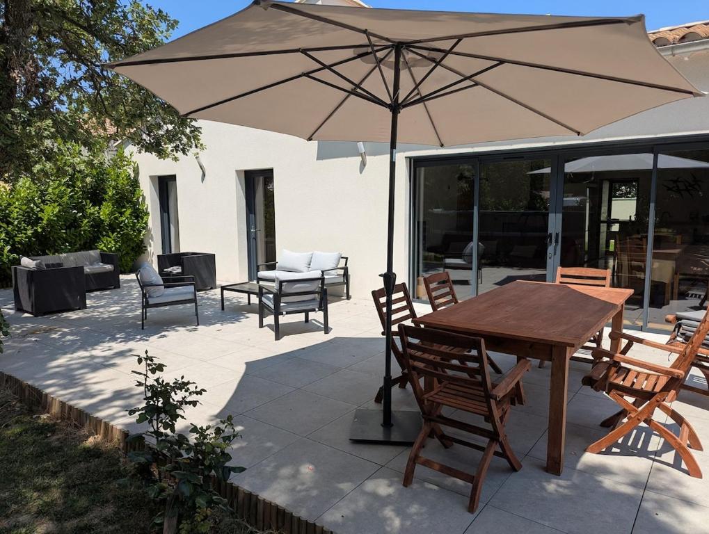 une table et des chaises avec un parasol sur une terrasse dans l'établissement Villa Les Chênes, à Saint-Victor-la-Coste