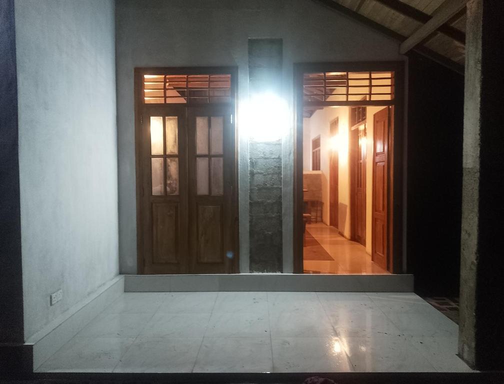 une pièce vide avec deux portes et une lumière dans l'établissement Farm House Hostel, à Negombo