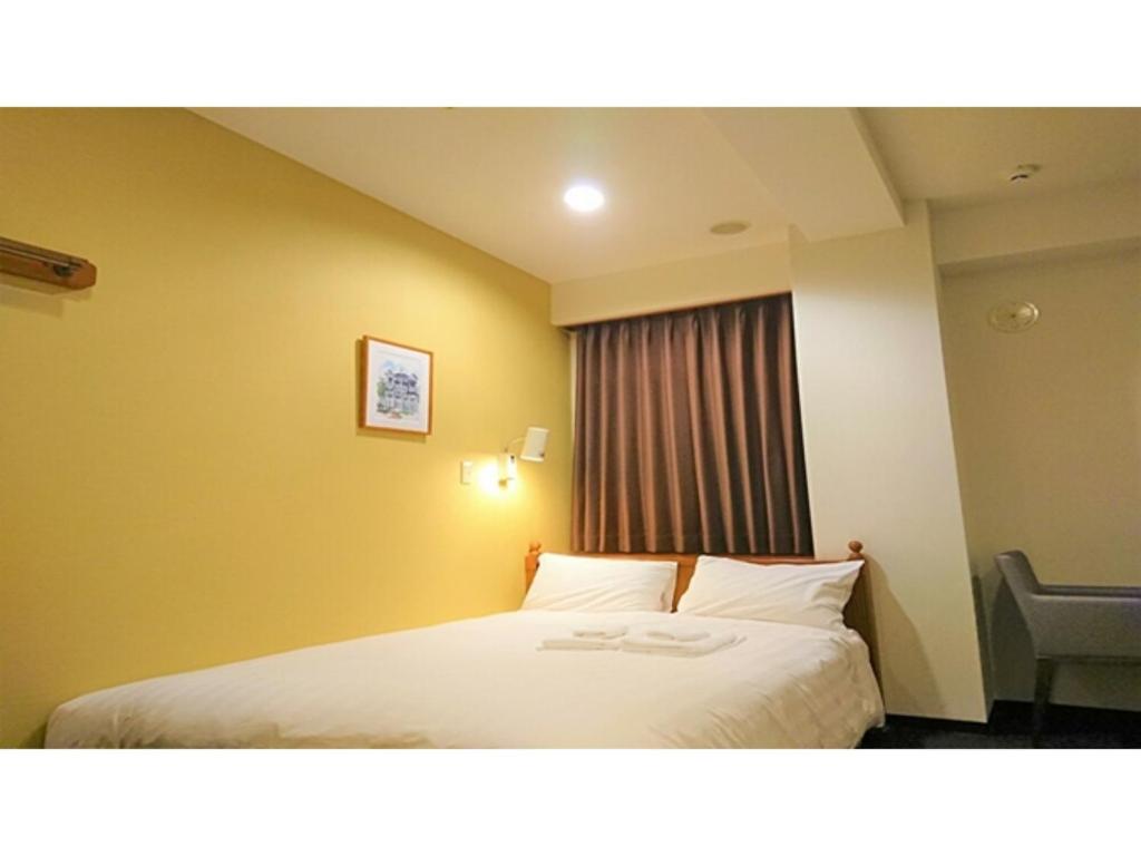 a hotel room with a bed and a window at Smile Hotel Kobe Motomachi - Vacation STAY 85861v in Kobe