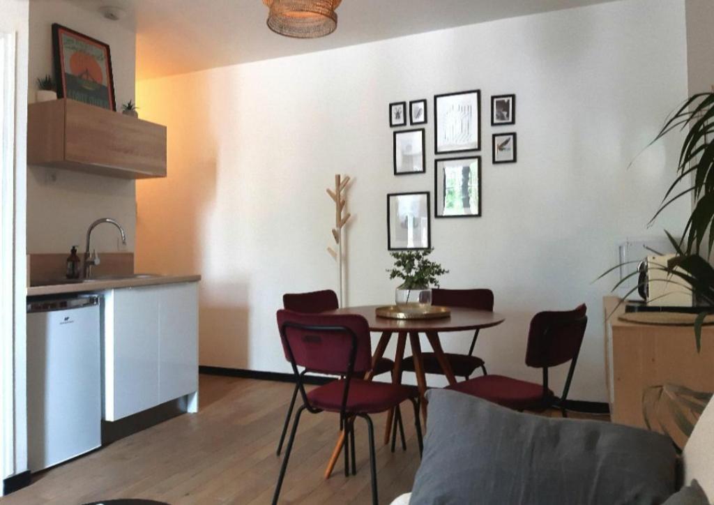 une cuisine et une salle à manger avec une table et des chaises dans l'établissement T2 cosy - gare, plage et intramuros à pied, à Saint-Malo
