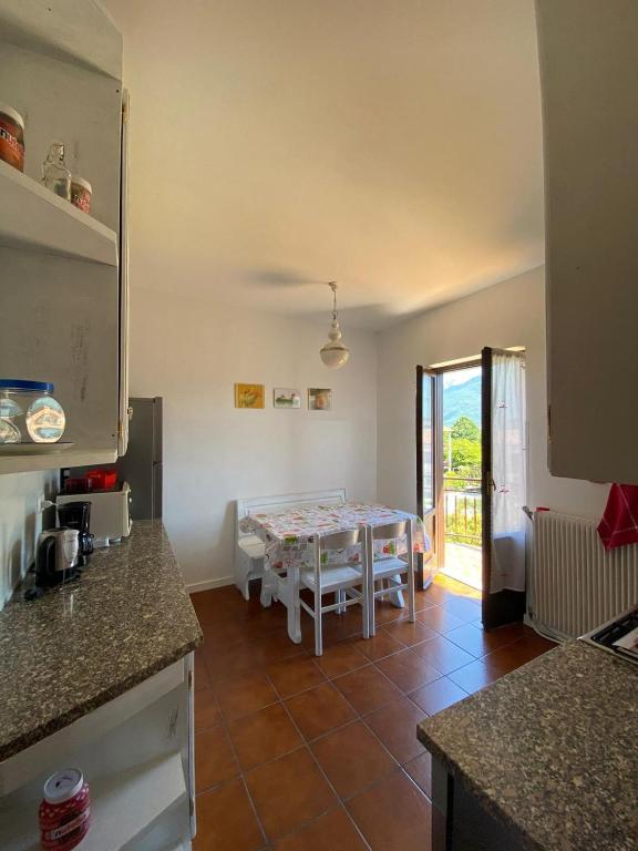 a kitchen with a table and a dining room at Appartamento Luisa 2 in Domaso