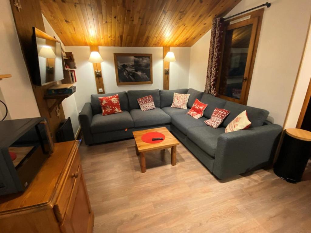 La Plagne TarentaiseLe Chalet De Montchavin - Bel appartement duplex proche du centre MAE-4254的客厅里有一张沙发和一张桌子。