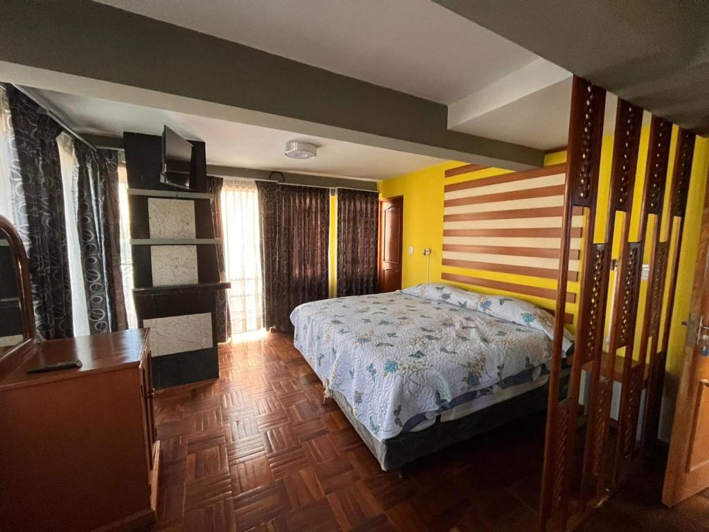 une chambre avec un lit avec une tête de lit en bois dans l'établissement Casa Corp 9, à Sucre