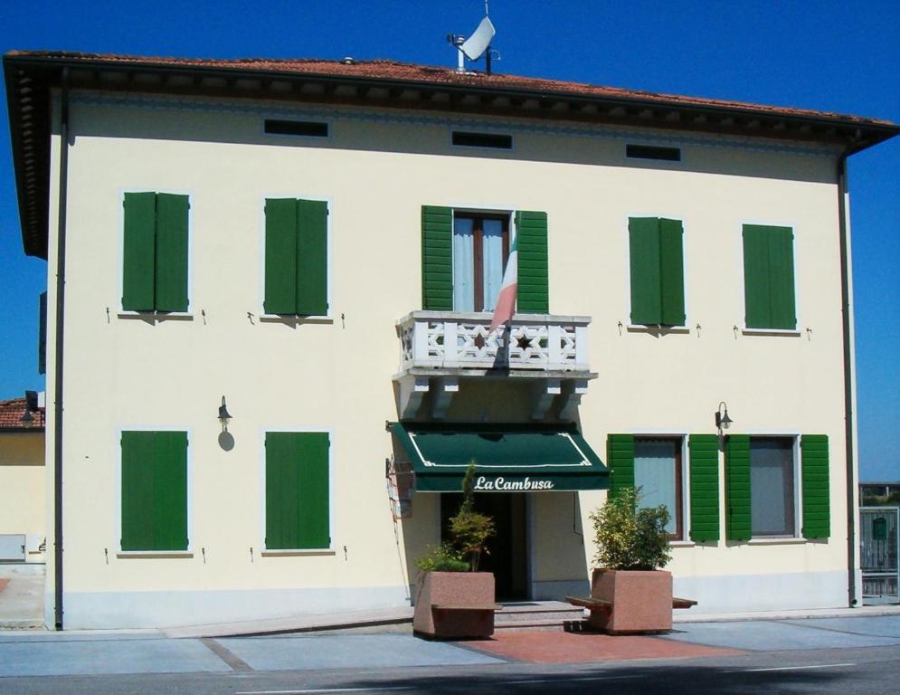 Motteggiana的住宿－B&B Cambusa，白色的建筑,设有绿色百叶窗和阳台