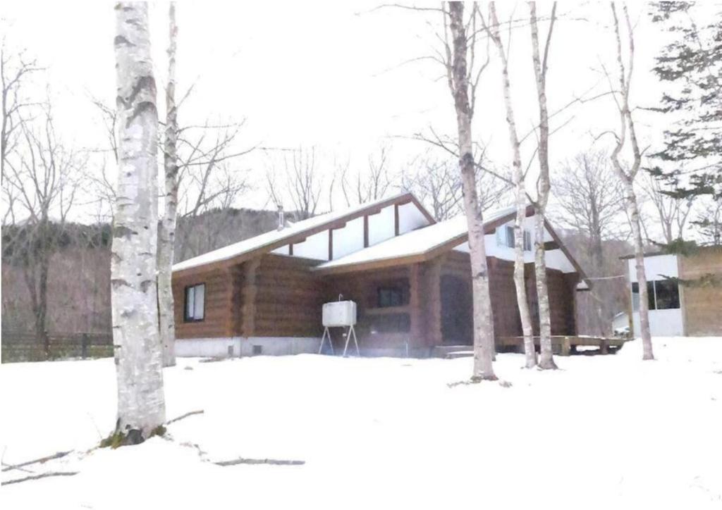 a log cabin in the snow with two trees at Noboribetsu City Log House - Vacation STAY 19798 in Noboribetsu