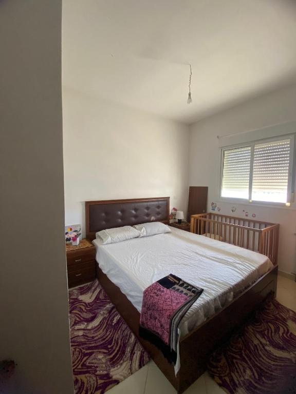 a bedroom with a large bed and a rug at شقة جاردينيا - طنجة البالية in Tangier