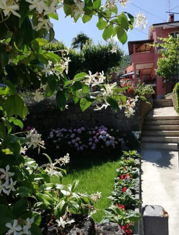 a garden with flowers and a stone wall at Apartman Kristina in Lovran