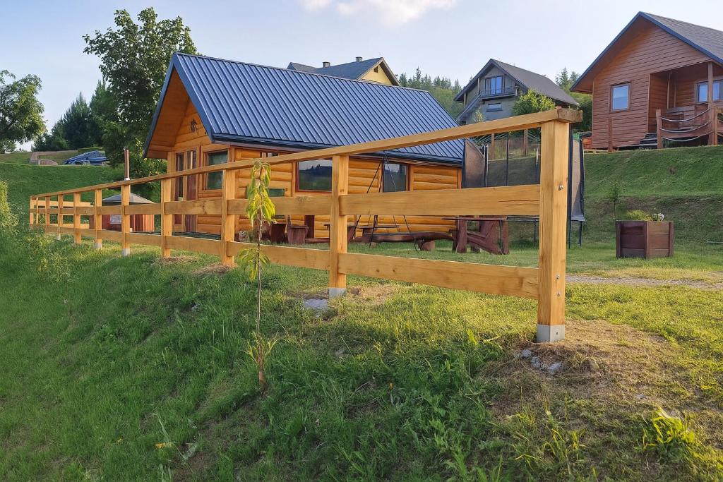 a wooden fence in front of a house at Przystanek Jawory 695-849-470 in Wołkowyja