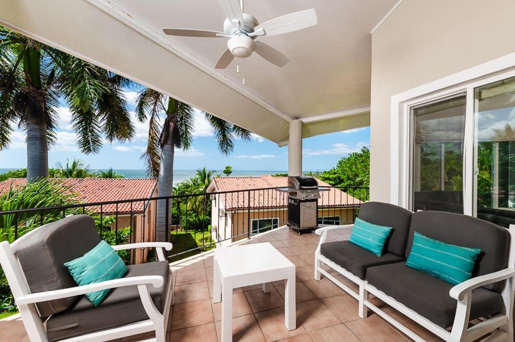 a patio with two chairs and a table and a grill at Beautiful 3 Bedroom Condo With Ocean Views in Tamarindo