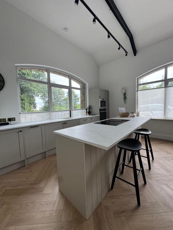 een keuken met een groot eiland met twee barkrukken bij The Reading Room, Shilbottle in Shilbottle