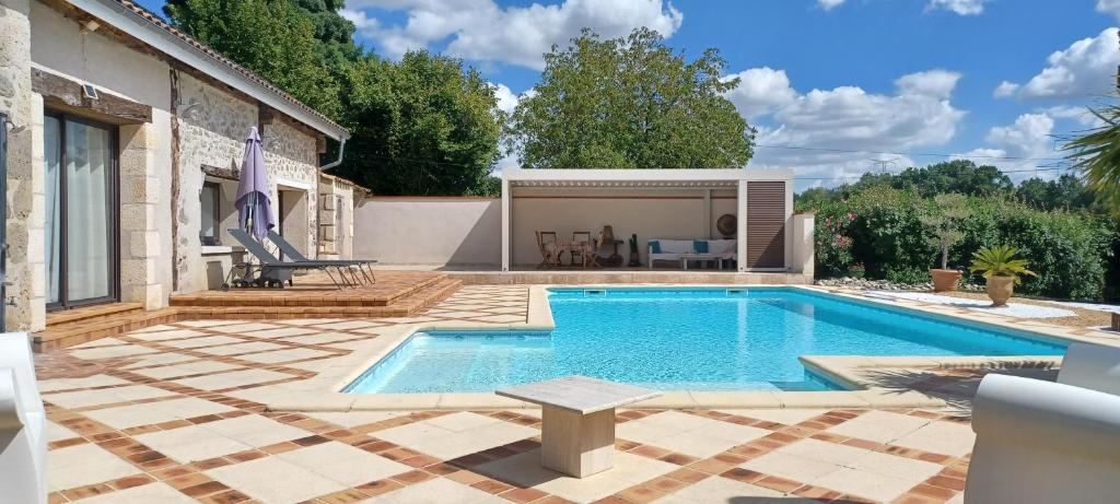 - une piscine avec une terrasse et une maison dans l'établissement Bienvenue au gîte du Caillou, à Montagnac-sur-Auvignon