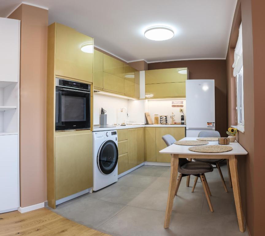 a kitchen with a table and a washer and dryer at Heart & Honey - The Romantic Loft in Plovdiv