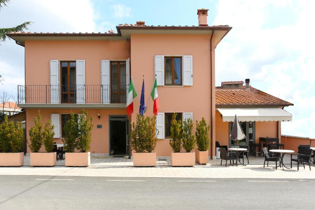 ein Haus mit zwei Flaggen davor in der Unterkunft Hotel Il Monte in Monte San Savino