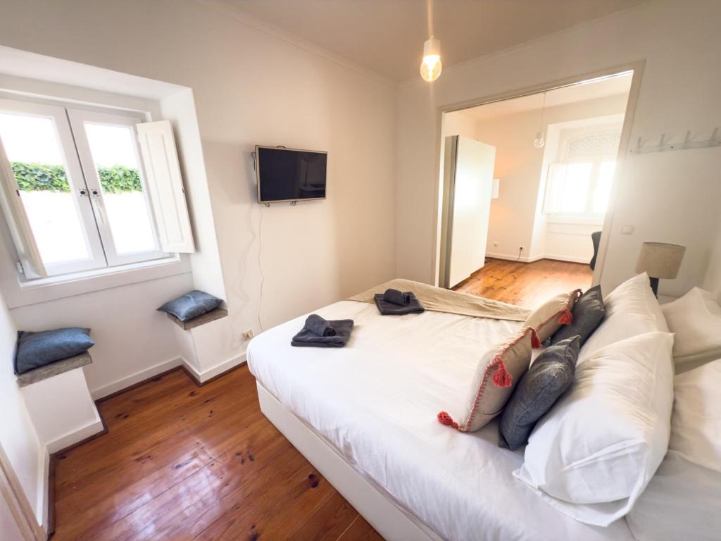 a bedroom with a white bed with pillows on it at T3 Apartment - Cascais Historic Center - 100m from Beach in Cascais