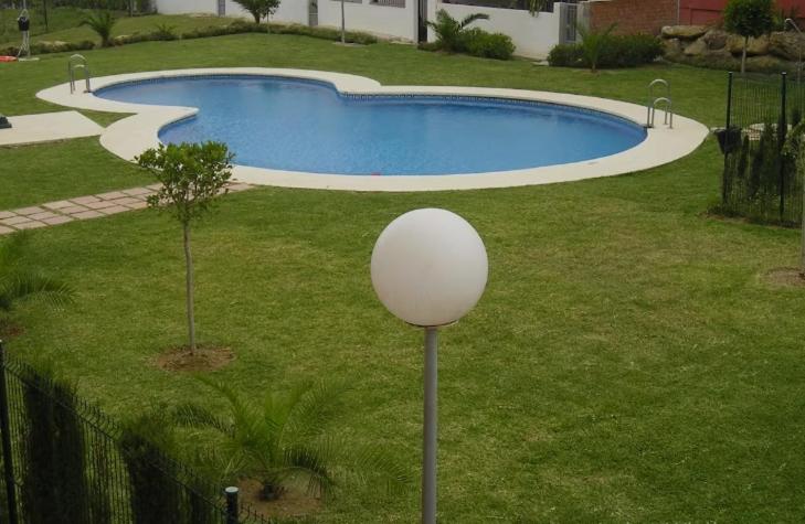 a large swimming pool in a yard with a lamp at Huerta Nueva Suites in Estepona