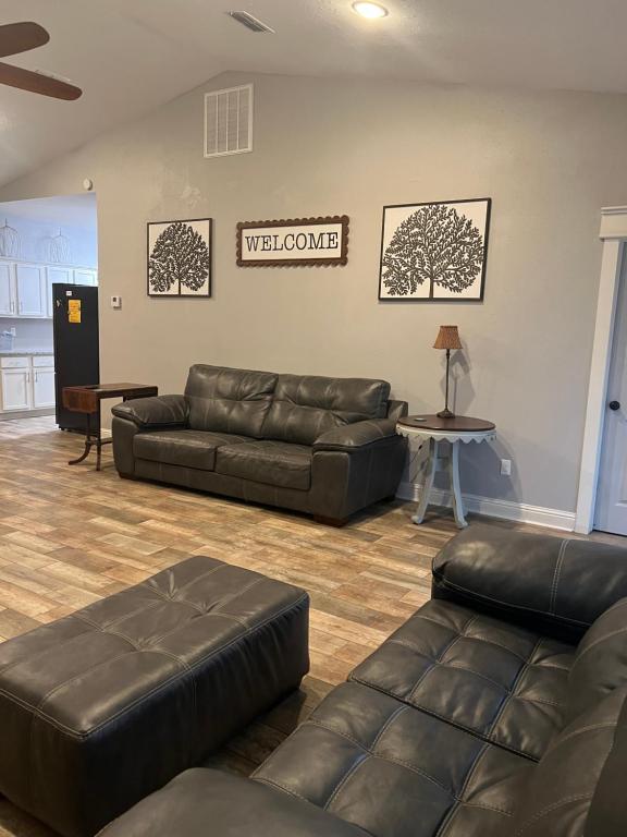 a living room with leather couches and a welcome sign at Morning Glory in Longview