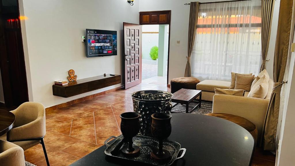 a living room with a table and a couch at Villa Modern Two Bedroom Vacation home in Mbezi Beach in Dar es Salaam