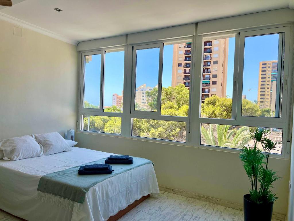 a bedroom with windows and a bed with towels on it at Estudio Vista Mar & Piscina - 200 m de la playa in Aguadulce