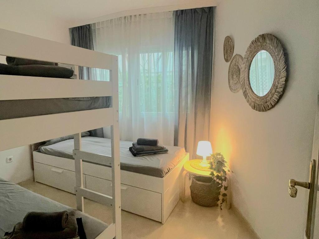ein kleines Schlafzimmer mit einem Etagenbett und einem Fenster in der Unterkunft Apartment Beachfront Accommodation in Estepona