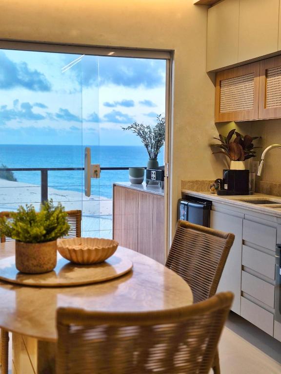 a kitchen with a table with a view of the ocean at Apto praia paradisíaca - Falésias de Pipa in Pipa
