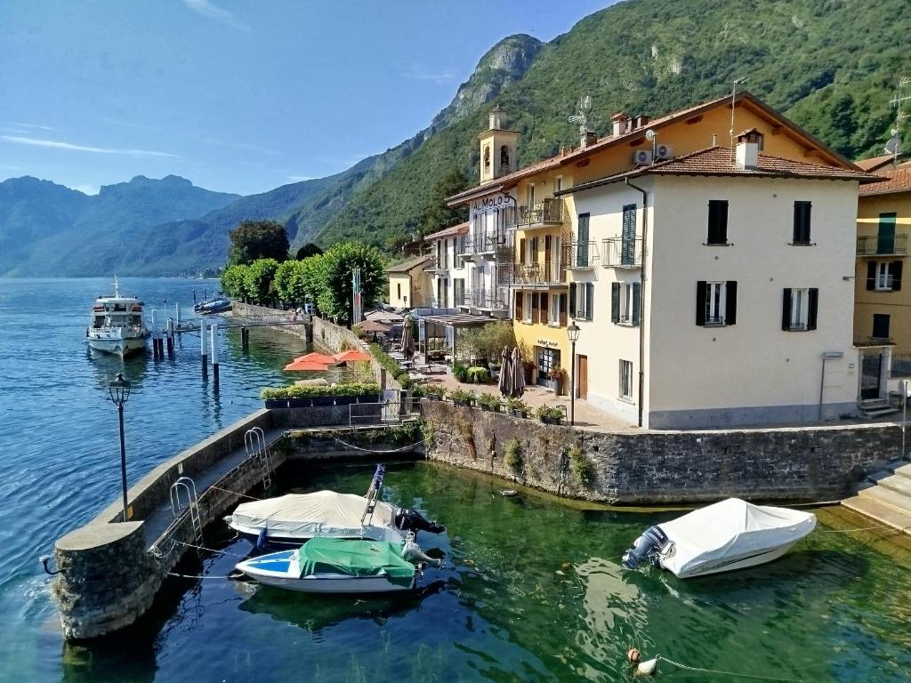 a group of boats docked in the water next to buildings at Domus Graziana - Lake Front in Oliveto Lario