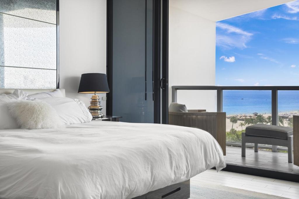 Un dormitorio con una cama blanca y una ventana grande. en Oceanview Private Home at South Beach-814 1B, en Miami Beach