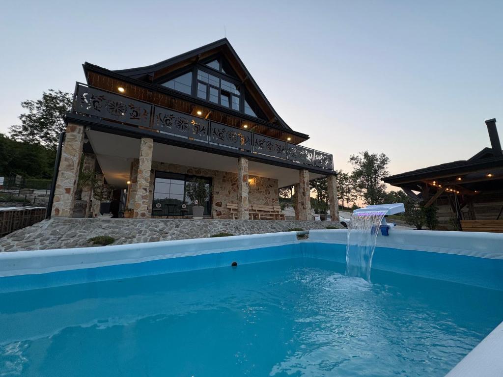 a house with a swimming pool in front of a building at Villa Ligęzówka in Chyrowa