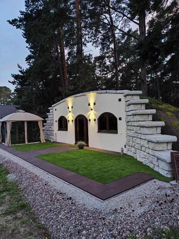 a small white house with a grass yard at Kotkapesa in Treimani