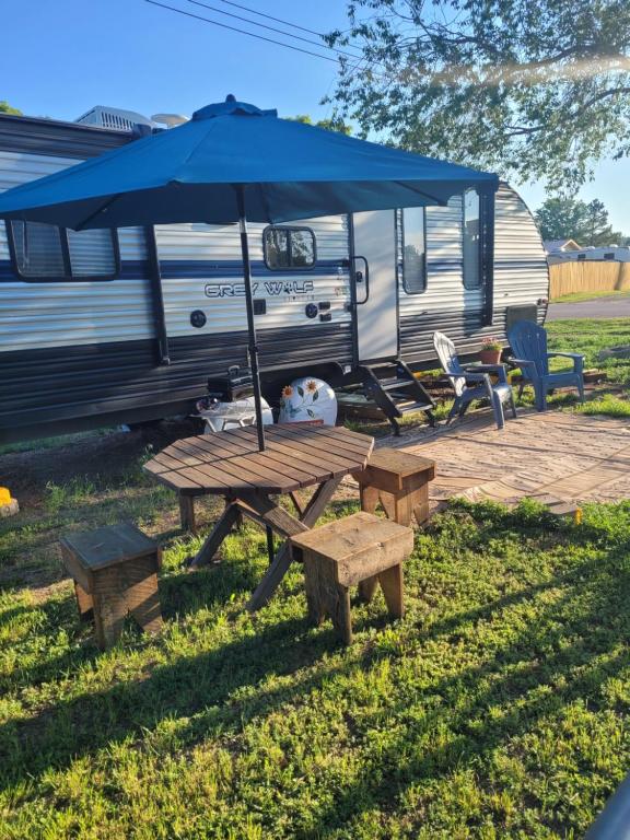 a picnic table with an umbrella next to a rv at Cozy Camping in Hot Springs