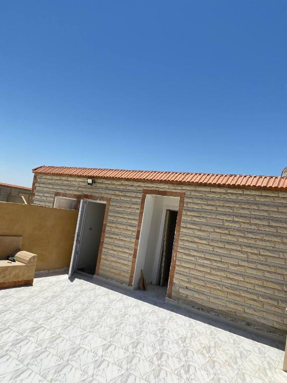 a building with a brick wall and a door at الإسكندرية in Dawwār Abū Duray‘ah ‘Abd al Karīm