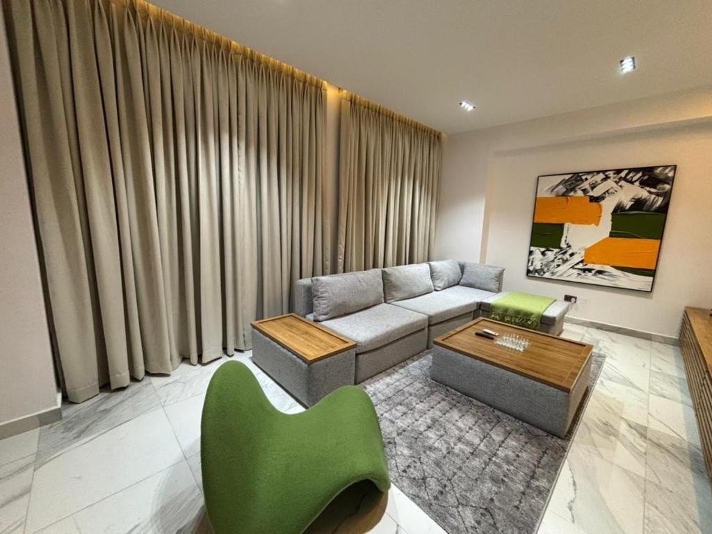 sala de estar con sofá y silla verde en Zeem luxury homes, en Lekki