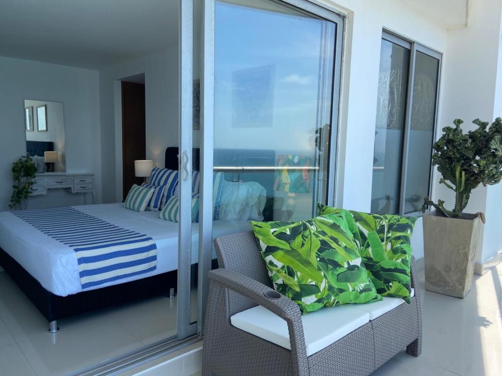 une chambre avec un lit, une chaise et une fenêtre dans l'établissement Alta Mar Ocean Sky, à Carthagène des Indes