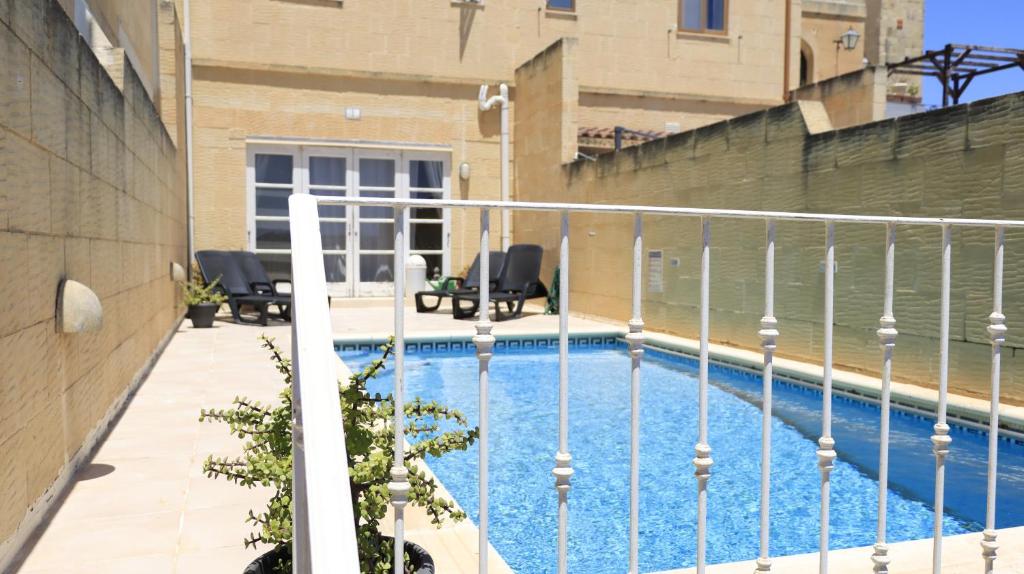a balcony with a swimming pool in a building at Villa Ambrose Village in San Lawrenz