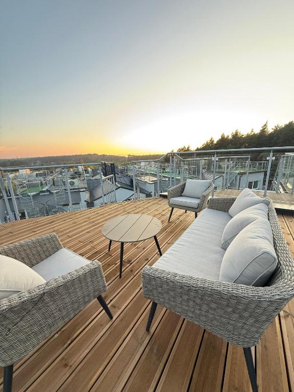 a balcony with two wicker chairs and a table at Apartamenty Oakland in Debina