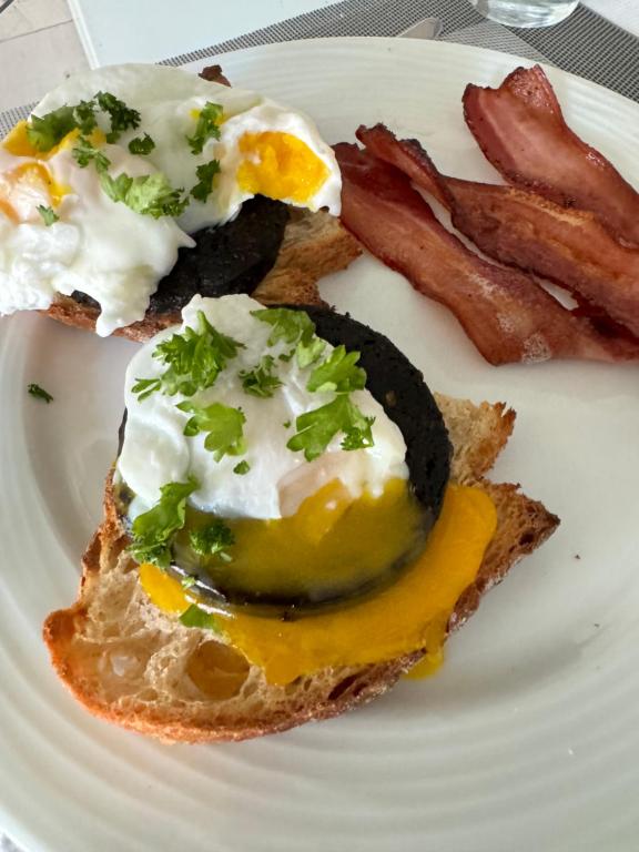 a plate of food with eggs and bacon at Hameaux du glaciers in Les Houches