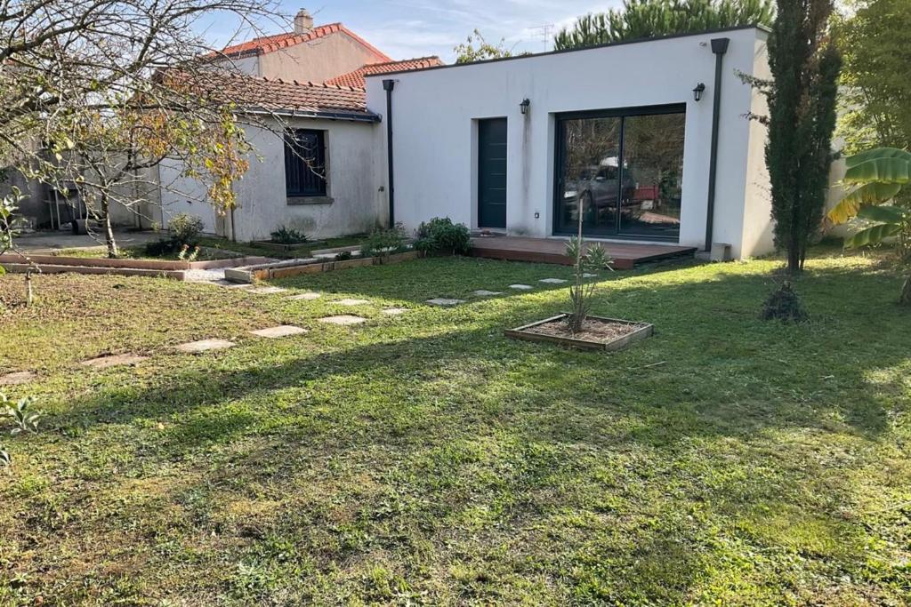 a house with a yard with a small tree in it at Bright house with garden in Saint-Sébastien-sur-Loire