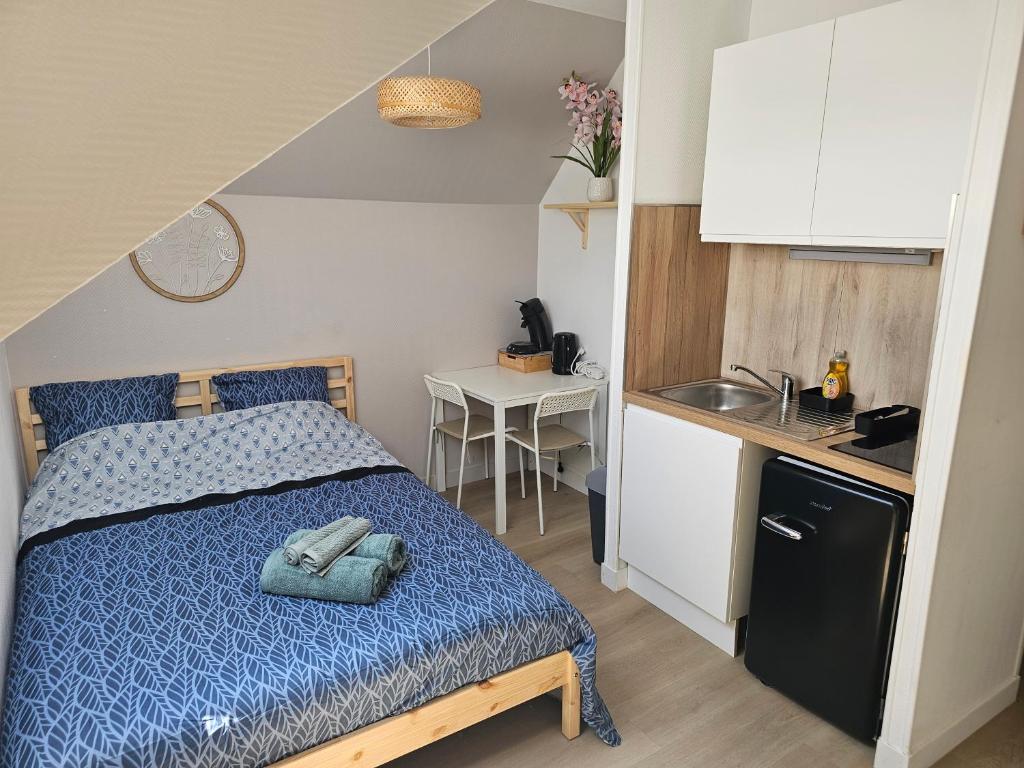 a small bedroom with a bed and a kitchen at Joli studio plein centre proche Gare Orléans in Orléans