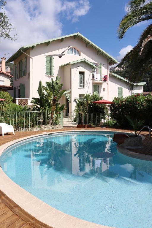une grande piscine devant une maison dans l'établissement La Villa Roseraie , Hôtel Familial OUVERT TOUTE L'ANNEE, à Vence