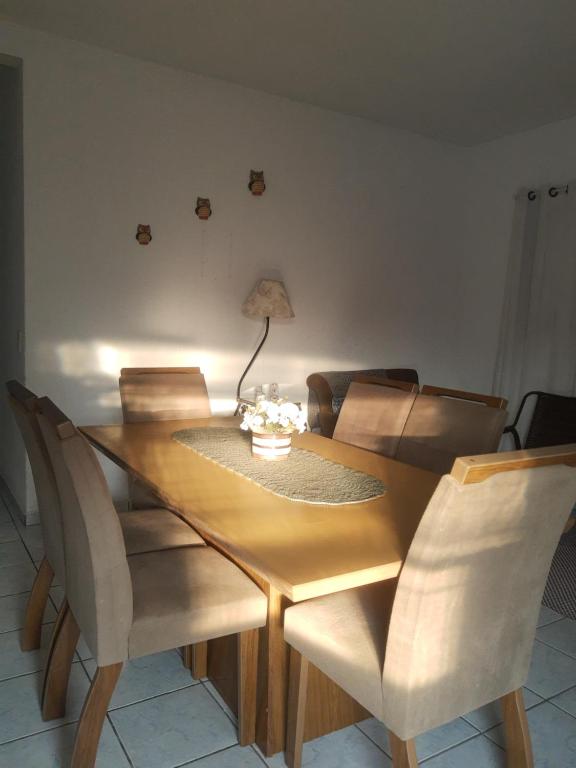a dining room table with chairs and a lamp on it at Cantinho da val in Aparecida