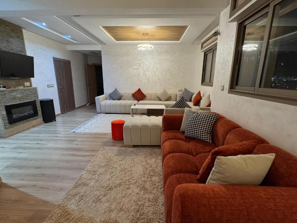 a living room with a couch and a living room with a fireplace at Bel appartement à ifrane in Ifrane