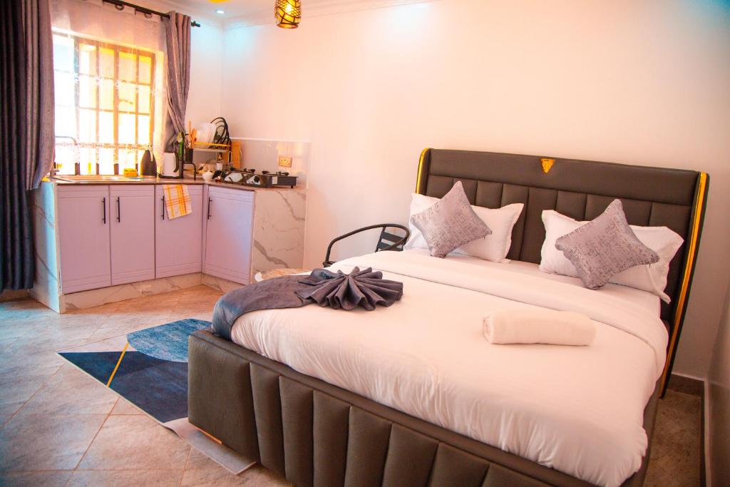 une chambre avec un grand lit et une cuisine dans l'établissement At Sekani Homes, à Eldoret