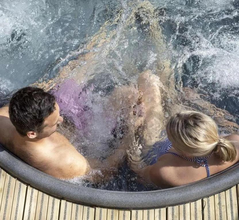a man and a woman in a hot tub at Seascape Seaview Apartment hot tub hire subject to availability in Scarborough