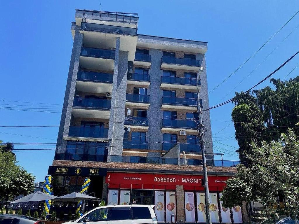 a tall building with cars parked in front of it at Kobuleti One in K'obulet'i